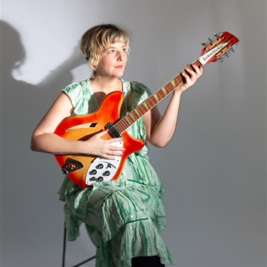 Musician Anna Hillburg holding a guitar.